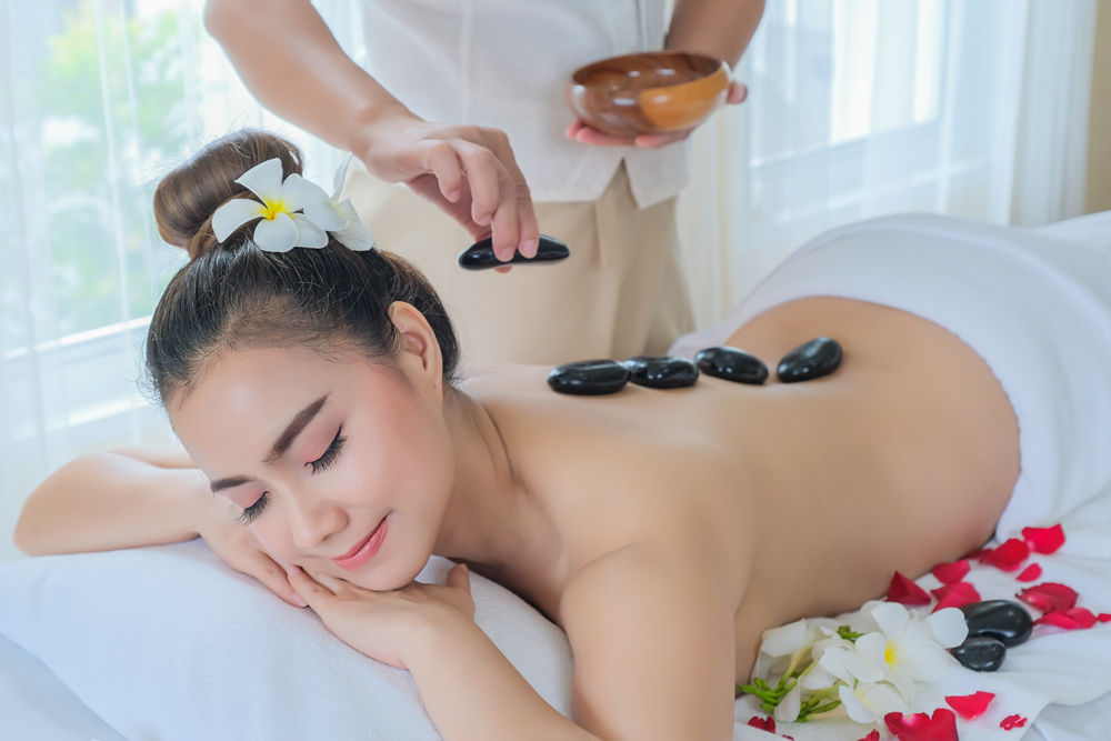 Woman enjoying a hot stone massage at a spa. Woman enjoying a hot stone massage at a spa.