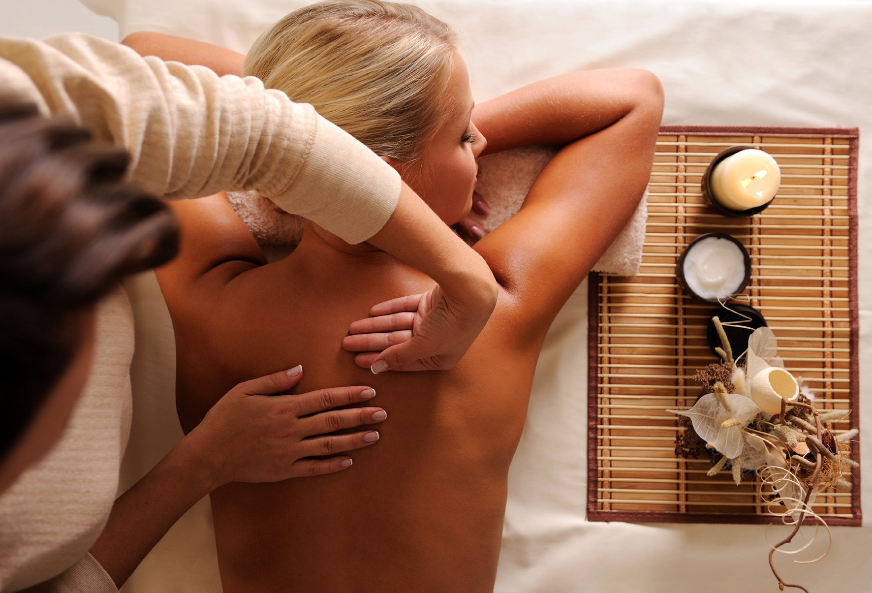 A woman receiving a relaxing back massage in a spa setting. A woman receiving a relaxing back massage in a spa setting.