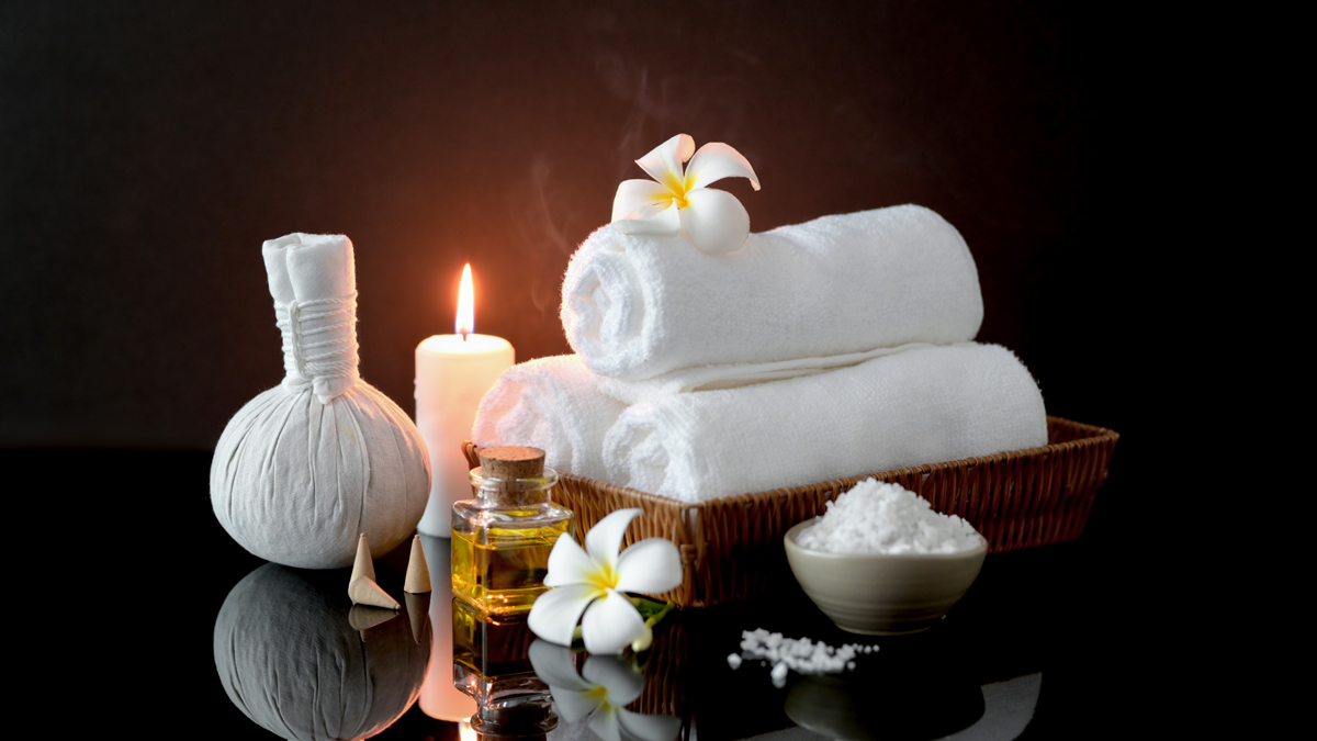Spa essentials with candles, towels, and flowers for relaxation. Spa essentials with candles, towels, and flowers for relaxation.